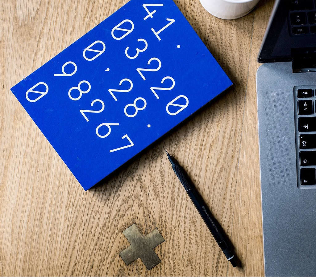 Numbers, pen and laptop on desk